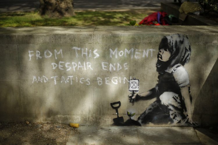 La sombra de un árbol sobre un mural que se sospecha podría ser de Banksy en una pared donde se había colocado el campamento de los manifestantes del grupo. Foto:Matt Dunham/ AP.