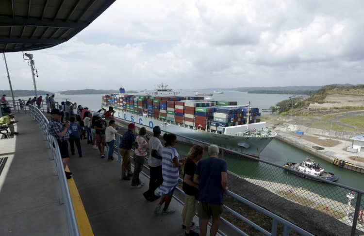 Turistas observan el paso de un buque de mercancías por la esclusa de Agua Clara del Canal de Panamá, el 20 de abril de 2019. Foto: Arnulfo Franco / AP.