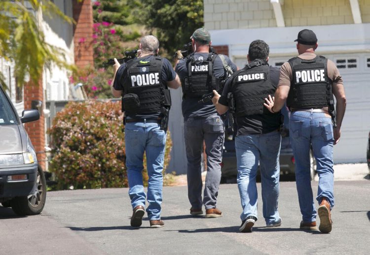 Agentes de policía de San Diego fuertemente armados se acercan a la casa donde se cree vivía John T. Earnest, de 19 años, sospechoso del tiroteo en una sinagoga de Poway, el sábado 27 de abril de 2019 en San Diego, California. Foto: John Gibbins/The San Diego Union-Tribune vía AP.