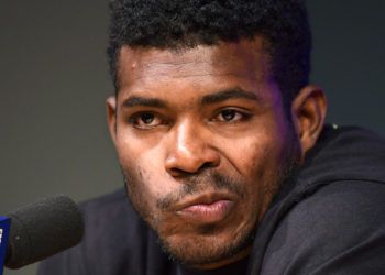 El cubano Yasiel Puig, de los Rojos de Cincinnati, hace una mueca mientras escucha preguntas de los reporteros antes del partido frente a los Dodgers de Los Ángeles, el lunes 15 de abril de 2019, en Los Ángeles. (AP Foto/Mark J. Terrill)