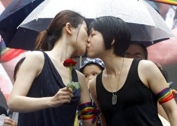 Dos muejres, activistas en favor del matrimonio homosexual, se besan en el exterior del parlamento de Taiwán, en Taipei, el 17 de mayo de 2019, tras la aprobación de una ley que legaliza las uniones entre personas del mismo sexo. (AP Foto/Chiang Ying-ying)