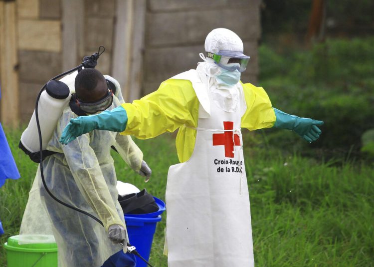 Fotografía de archivo del 9 de septiembre de 2018 de un trabajador rociando desinfectante a su colega luego de trabajar en un centro de tratamiento de ébola en Beni, Congo. Foto: AP/Al-hadji Kudra Maliro\Archivo.