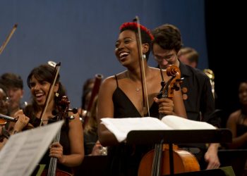 Integrantes de la Cuban American Youth Orchestra (CAYO) ríen durante una presentación en el Teatro Nacional de La Habana, el sábado 25 de mayo de 2019 en su primera gira por la isla. La orquesta juvenil cubano-estadounidense tiene músicos de importantes instituciones de ambos países como New World Symphony, Juilliard, el Instituto Superior de Arte de Cuba y la Orquesta de Cámara de Cuba. (Foto AP/Ismael Francisco)