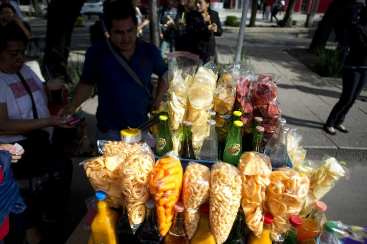 Un vendedor callejero vende bocadillos fritos envueltos en bolsas de plástico en Ciudad de México, el 5 de julio de 2016. Foto: Eduardo Verdugo / AP.