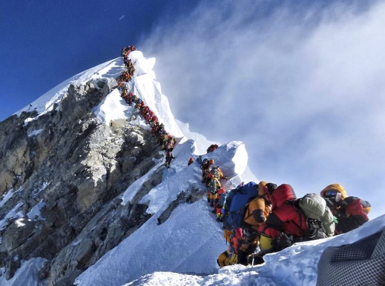 En esta fotografía del 22 de mayo de 2019, una larga fila de montañeros ascienden al pico del Everest. (Nimsdai Project Possible vía AP)