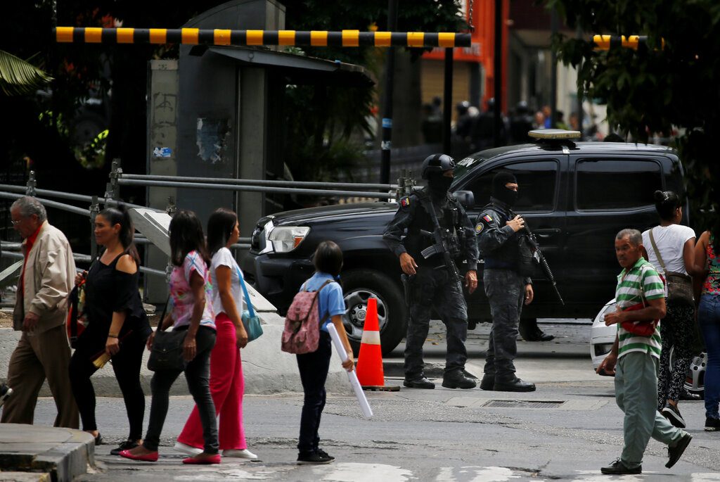 Agentes enmascarados del servicio de inteligencia de Venezuela montan guardia en la entrada del Congreso, controlado por la oposición, donde se ha bloqueado el acceso a los legisladores y al público, en Caracas, Venezuela, el martes 14 de mayo de 2019. (AP Foto / Fernando Llano)