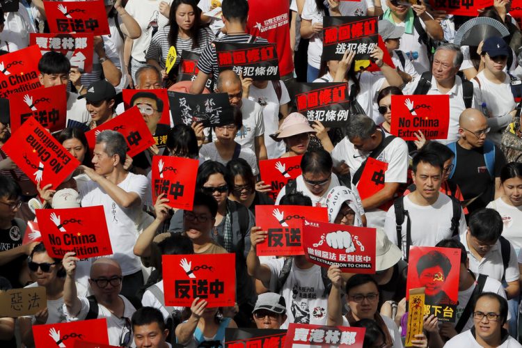 Manifestantes sostienen carteles en una marcha contra las enmiendas propuestas a una ley de extradiciones en Hong Kong, el domingo 9 de junio de 2019. Foto: Kin Cheung/ AP.