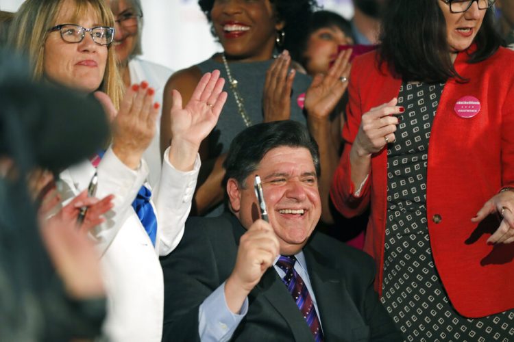 El gobernador de Illinois, J.B. Pritzker firma la Ley de Salud Reproductiva junto a los patrocinadores de la propuesta, la senadora estatal Melinda Bush, a la izquierda, y la representante estatal Kelly Cassidy, a la derecha, en el Centro Cultural de Chicago, el miércoles 12 de junio de 2019. Foto: Jose M. Osorio/Chicago Tribune via AP.