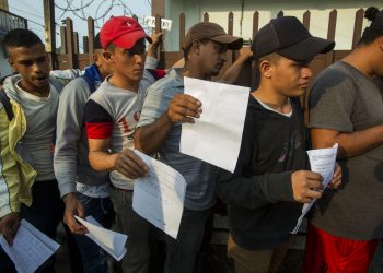 Migrantes centroamericanos hacen fila afuera de la Comisión Mexicana de Ayuda al Refugiado en Tapachula para obtener los documentos necesarios que les permiten permanecer en México, el jueves 20 de junio de 2019. Foto: Oliver de Ros / AP.