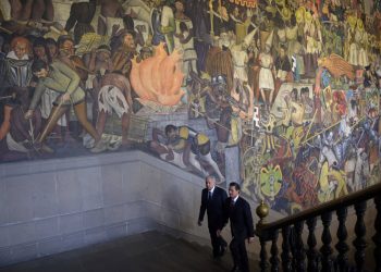 El presidente mexicano Enrique Peña Nieto camina el 9 de agosto de 2018 con el entonces presidente electo Andrés Manuel López Obrador frente a un mural de Diego Rivera en el Palacio Nacional, México. Foto: Oficina de prensa presidencial de México vía AP.