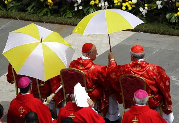 Cardenales refugiados del sol durante la misa de Pentecostés celebrada por el papa Francisco en la Plaza de San Pedro, en el Vaticano, el domingo 9 de junio de 2019. Foto: Gregorio Borgia/ AP.
