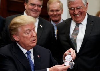 El presidente Trump sostiene una estatuilla que le entregara el astronauta del Apolo 17, Jack Schmitt, luego de firmar una directiva para enviar a los astronautas estadounidenses de regreso a la luna, y finalmente a Marte. 11 de diciembre de 2017. Foto: Evan Vucci / AP.