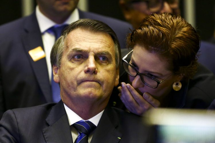 El presidente Jair Bolsonaro escucha mientras Carla Zambelli le susurra algo durante una reunión en el Congreso en Brasilia, Brasil en una fotografía del 29 de mayo de 2019 proporcionada por Agencia Brasil. Foto: Marcelo Camargo/Agencia Brasil vía AP.