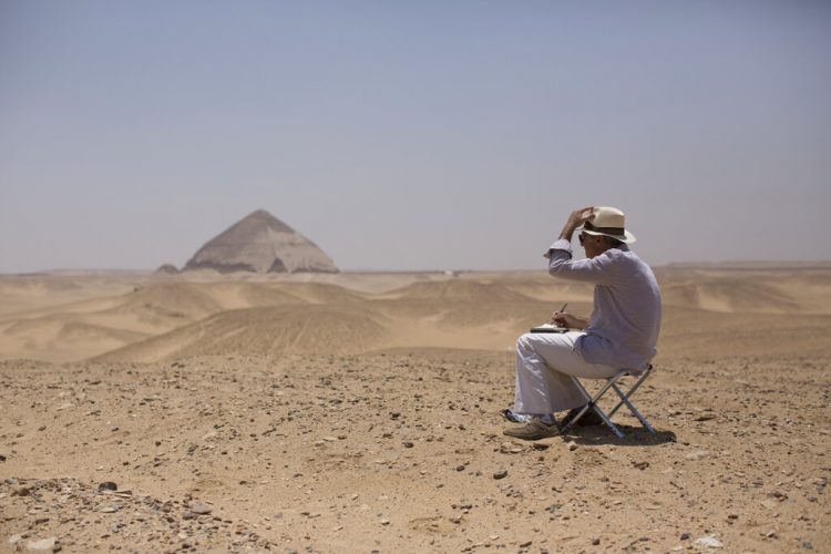 Un miembro de una delegación internacional dibuja el sitio de la Pirámide de Bent durante un evento de apertura para los visitantes de la pirámide y sus entornos en Dashur, Egipto, el sábado 13 de julio de 2019. Foto AP/Maya Alleruzzo.