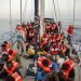 Unos migrantes descansan en un barco del grupo humanitario italiano Mediterranea Saving Humans frente a la costa de la isla más al sur de Italia de Lampedusa, el jueves 4 de julio de 2019. Foto: Olmo Calvo / AP.