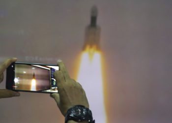 Un hombre en el Planetario Nehru de Nueva Delhi toma fotos de la transmisión por internet del despegue del vehículo de lanzamiento satelital Geosynchronous de la Organización de Investigación Espacial India en el centro espacial Satish Dhawan en la India. Foto: Manish Swarup / AP.