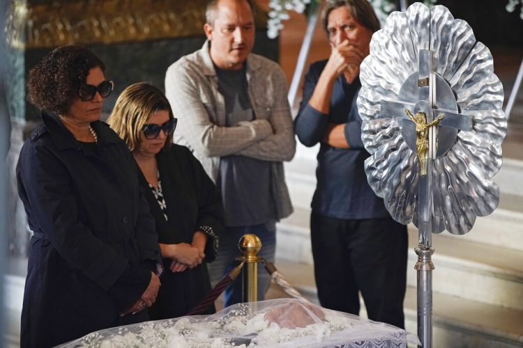 Maria do Ceu Harris, a la izquierda, la viuda de Joao Gilberto, observa el cuerpo del ícono cultural brasileño durante su funeral en el Teatro Municipal en Rio de Janeiro, el lunes 8 de julio del 2019. Foto: Leo Correa / AP.