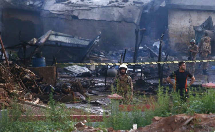 Efectivos del ejército paquistaní examinan el lugar donde cayó un avión en Rawalpindi, Pakistán, el martes 30 de julio de 2019. (AP Foto/Anjum Naveed)