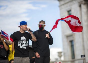 Los artistas puertorriqueños René Pérez “Residente” y Benito Antonio Martinez Ocasio “Bad Bunny” avivan a la gente previo a una manifestación frente al capitolio puertorriqueño contra el gobernador Ricardo Roselló, en San Juan, Puerto Rico, el miércoles 17 de julio de 2019. Foto: Dennis Rivera/AP.