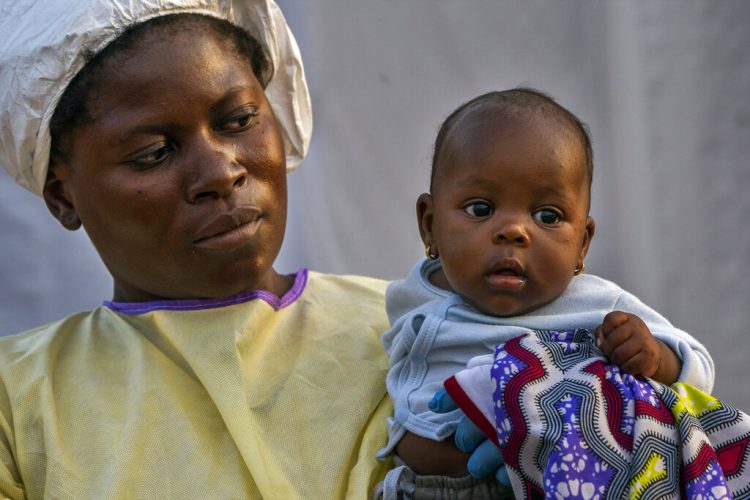 En esta image, tomada el 17 de julio de 2019, Lahya Kathembo, de dos meses, espera en los brazos de una enfermera a los resultados de una prueba de ébola en un centro de tratamiento de la enfermedad en Beni, República Democrática del Congo. (AP Foto/Jerome Delay)