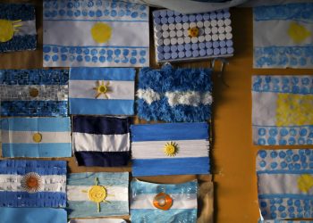Banderas argentinas están en una pared en una escuela usada como casilla para votar durante las elecciones primarias en Buenos Aires, Argentina, el domingo 11 de agosto de 2019. (AP Foto/Natacha Pisarenko)