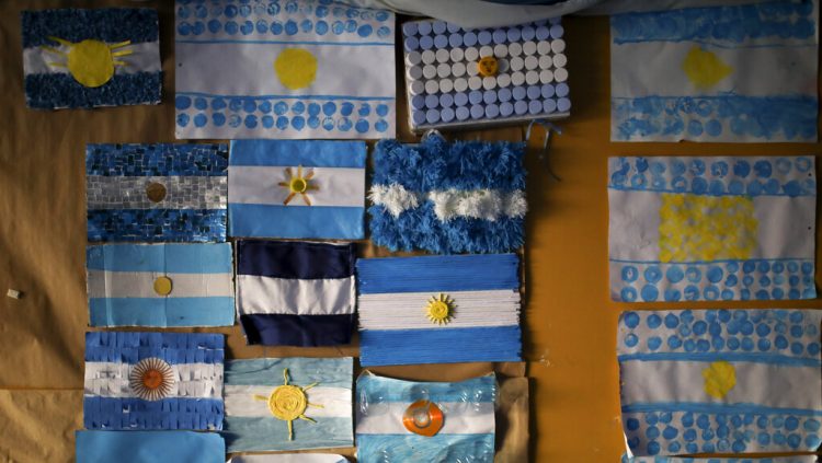 Banderas argentinas están en una pared en una escuela usada como casilla para votar durante las elecciones primarias en Buenos Aires, Argentina, el domingo 11 de agosto de 2019. (AP Foto/Natacha Pisarenko)
