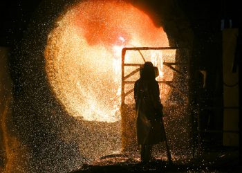 En esta imagen del martes 5 de marzo de 2019, un empleado con uniforme de seguridad trabaja en una fundidora de acero durante un recorrido de prensa en la siderúrgica Salzgitter AG en Salzgitter. (AP Foto/Markus Schreiber)