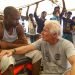 El actor Richard Gere, derecha, habla con migrantes al bordo del buque humanitario Open Arms durante el cruce del Mediterráneo, viernes 9 de agosto de 2019. (AP Foto/Valerio Nicolosi)