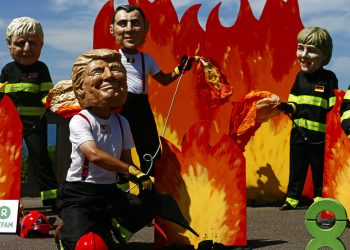 Un hombre con máscara del presidente estadounidense Donald Trump y otros "líderes mundiales" participan de una protesta en vísperas de la cumbre del G7 en Biarritz, Francia, viernes 23 de agosto de 2019. (AP Foto/Peter Dejong)