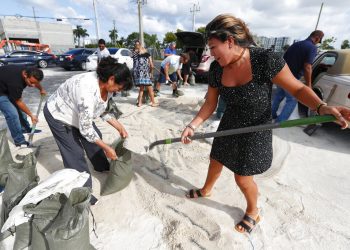 Georgia Bernard (derecha) y Ana Pérez, junto a otros residentes, llenan sacos de arena para llevárselos a casa antes de la llegada del potente huracán Dorian, el 30 de agosto de 2019, en Hallandale Beach, Florida. Foto: Wilfredo Lee/ AP.
