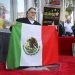 El cineasta mexicano Guillermo del Toro posa con la bandera de México tras una ceremonia en su honor para develar su estrella en el Paseo de la Fama de Hollywood el martes 6 de agosto de 2019 en Los Angeles. Foto: Willy Sanjuan/Invision/AP.