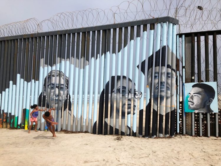 Dos niños juegan frente a un nuevo mural en el lado mexicano del muro fronterizo en Tijuana, México, el viernes 9 de agosto de 2019. Foto: Elliot Spagat/ AP.