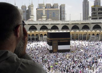 Un peregrino musulmán reza mientras observa como miles de fieles rodean la Kaaba, el edificio cúbico de la Gran Mezquita, antes del inicio de peregrinaje del Haj, en la ciudad santa musulmana de La Meca, Arabia Saudí, el 8 de agosto de 2019. (AP Foto/Amr Nabil)