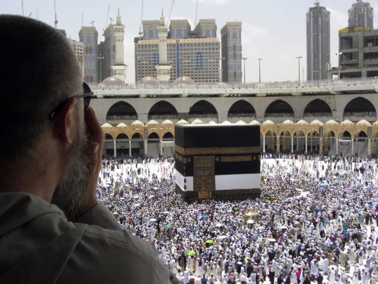 Un peregrino musulmán reza mientras observa como miles de fieles rodean la Kaaba, el edificio cúbico de la Gran Mezquita, antes del inicio de peregrinaje del Haj, en la ciudad santa musulmana de La Meca, Arabia Saudí, el 8 de agosto de 2019. (AP Foto/Amr Nabil)