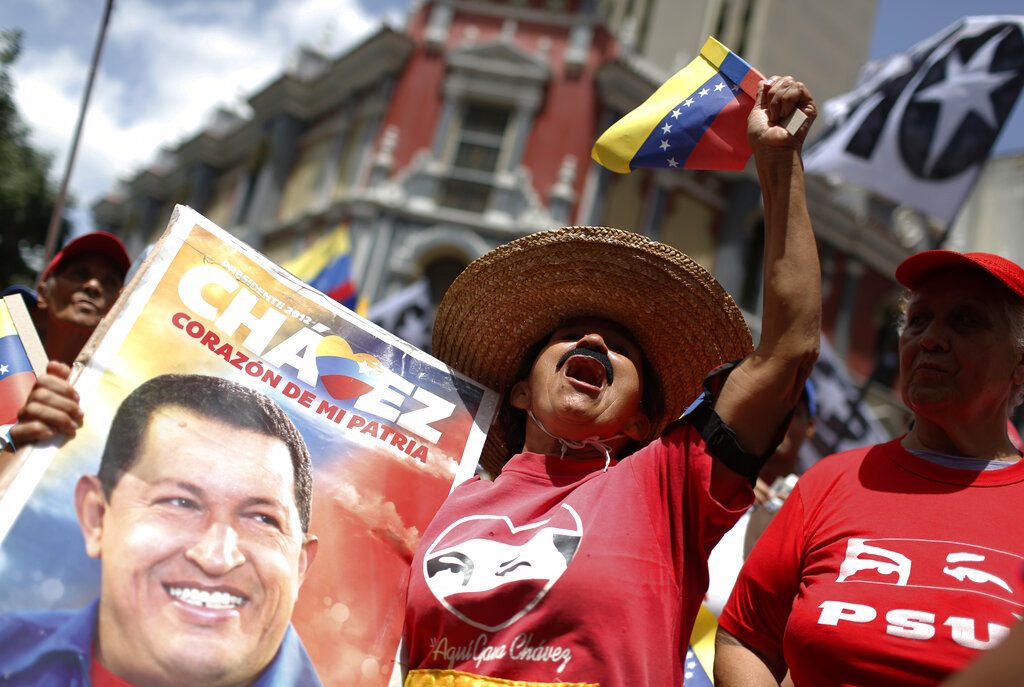 Una seguidora del gobierno que sostiene una imagen del fallecido presidente venezolano Hugo Chávez vitorea durante un mitin oficialista en Caracas, Venezuela, el sábado 27 de julio de 2019. Foto: Leonardo Fernández / AP / Archivo.