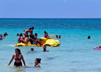 Un grupo de personas disfruta de un día de playa este verano en La Habana. Foto: Ernesto Mastrascusa / EFE.