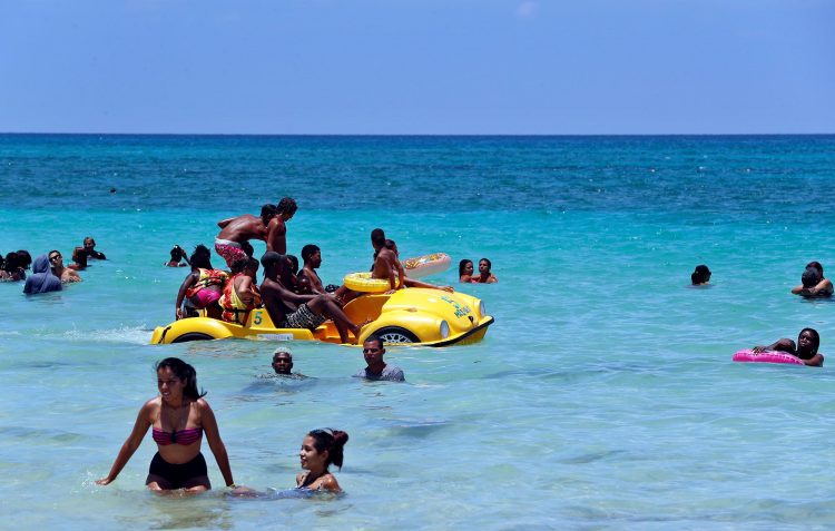 Un grupo de personas disfruta de un día de playa este verano en La Habana. Foto: Ernesto Mastrascusa / EFE.