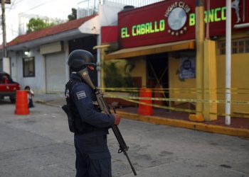 Un agente de policía custodia el exterior de un bar donde fallecieron más de una veintena de personas luego de un ataque nocturno, en Coatzacoalcos, México, el 28 de agosto de 2019. (AP Foto/Félix Márquez)