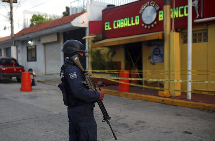Un agente de policía custodia el exterior de un bar donde fallecieron más de una veintena de personas luego de un ataque nocturno, en Coatzacoalcos, México, el 28 de agosto de 2019. (AP Foto/Félix Márquez)