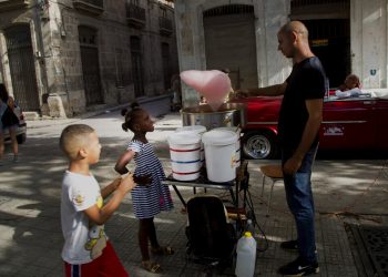 Una niña observa a un vendedor de algodones de azúcar en la Habana Vieja, Cuba, en agosto de 2019. Foto: Ismael Francisco / AP.