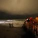 Varias personas caminan por el malecón mientras las bandas exteriores del huracán Dorian llegan a Vero Beach, Florida, la noche del lunes 2 de septiembre de 2019. (Foto AP/Gerald Herbert)