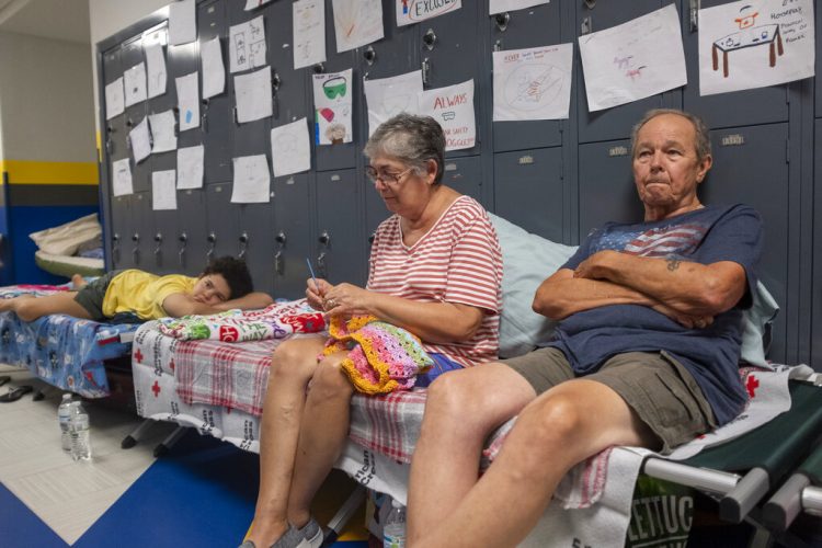 Personas sentadas en catres en el pasillo de la escuela secundaria North Myrtle Beach, que se está utilizando como refugio de evacuación de la Cruz Roja ante el huracán Dorian en Estados Unidos, el miércoles 4 de septiembre de 2019. Foto: Jason Lee/The Sun News via AP.
