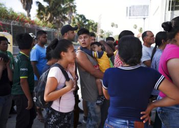 En esta fotografía de archivo del 1 de agosto de 2019, migrantes hacen fila en Matamoros, México, para recibir una comida donada por voluntarios estadounidenses, en el puente Puerto México que cruza hacia Brownsville, Texas. Foto: Emilio Espejel / AP / Archivo.