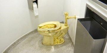 Imagen tomada de un video del 16 de septiembre de 2016 que muestra un inodoro de oro puro de 18 quilates, titulado "América", de Mauricio Cattelan, en el baño del museo Solomon R. Guggenheim de Nueva York. El inodoro, valuado en 1 millón de dólares, fue robado del Palacio Blenheim, en Inglaterra, donde formaba parte de una exposición. Foto: AP / Archivo.