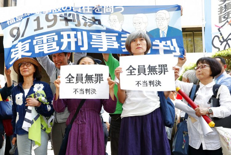 Un grupo de activistas sostiene carteles que dicen "sentencia injusta" ante la Corte del Distrito de Tokio, el jueves 19 de septiembre de 2019. La corte declaró no culpables de negligencia a tres exdirectivos de la eléctrica TEPCO por el desastre nuclear de Fukushima en 2011. 
Foto: Satoru Yonemaru/Kyodo News via AP.