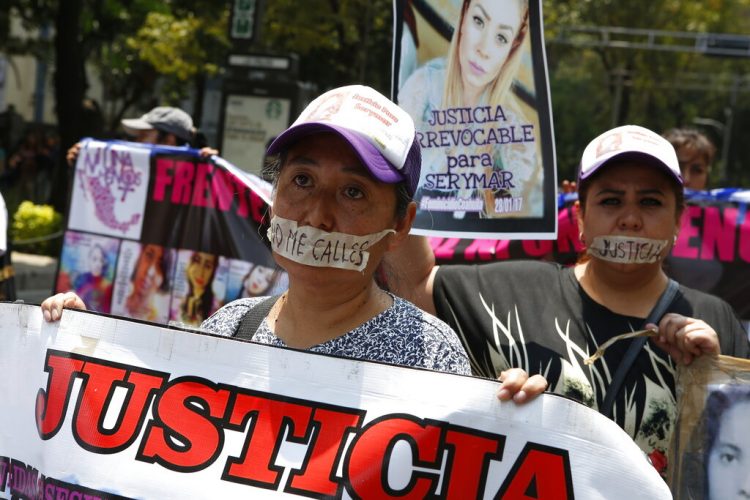 Madres de familia marchan con la boca cubierta con cinta durante una protesta silenciosa para exigir se les haga justicia a las mujeres que han sido asesinadas, el domingo 8 de septiembre de 2019, en la Ciudad de México. Foto: Ginnette Riquelme / AP.