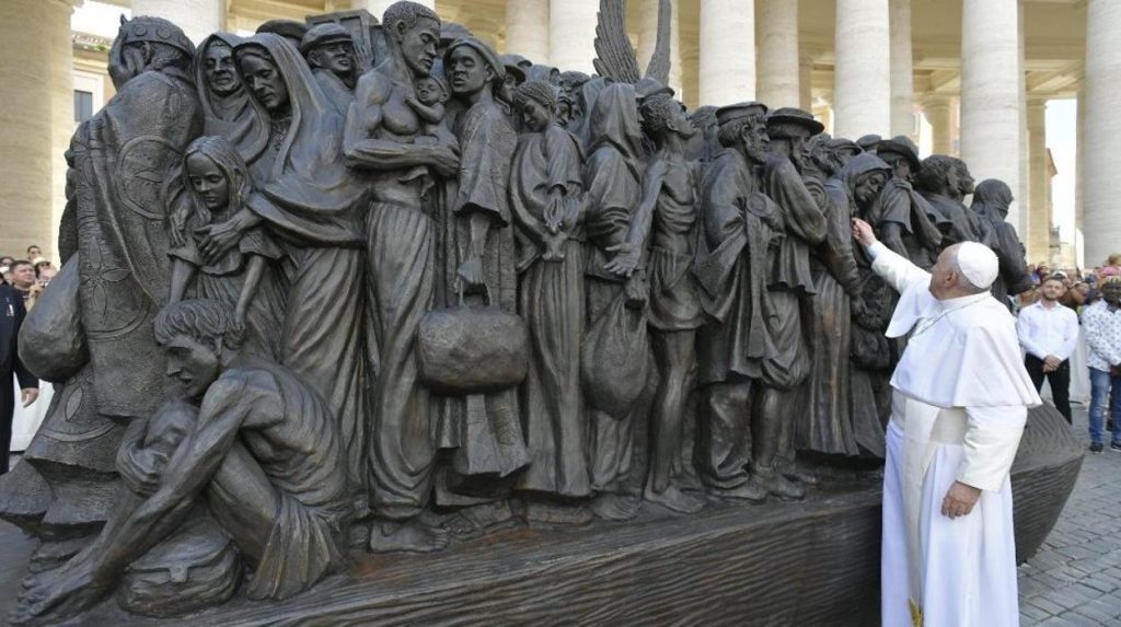 El Papa Francisco junto a una escultura de bronce que muestra a migrantes en un bote abarrotado, en la plaza de San Pedro, en el Vaticano, el 29 de septiembre de 2019. Foto: @aciprensa / Twitter.