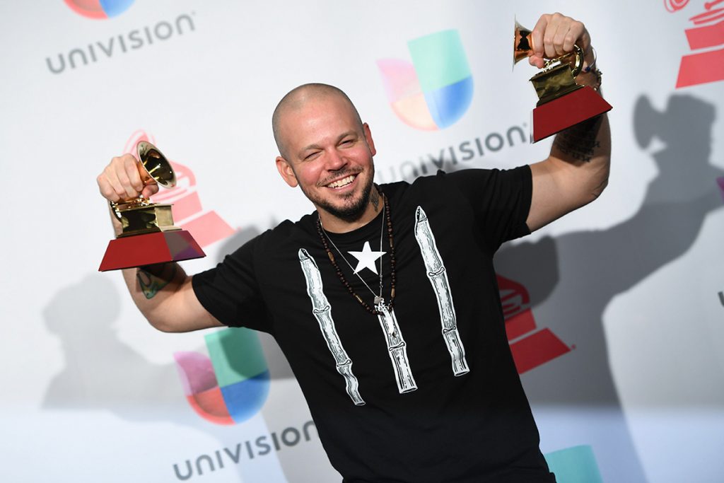 El puertorriqueño René Pérez, Residente, posa con dos premios Grammy Latinos ganados en 2017. Foto: umomag.com / Archivo.