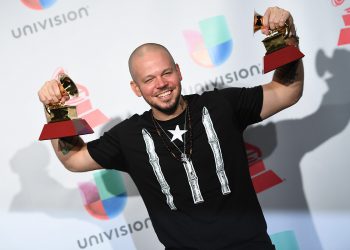 El puertorriqueño René Pérez, Residente, posa con dos premios Grammy Latinos ganados en 2017. Foto: umomag.com / Archivo.