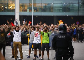 Policías antimotines vigilan las acciones de los manifestantes afuera del aeropuerto El Prat en Barcelona, España, el lunes 14 de octubre de 2019. Foto: Emilio Morenatti / AP.